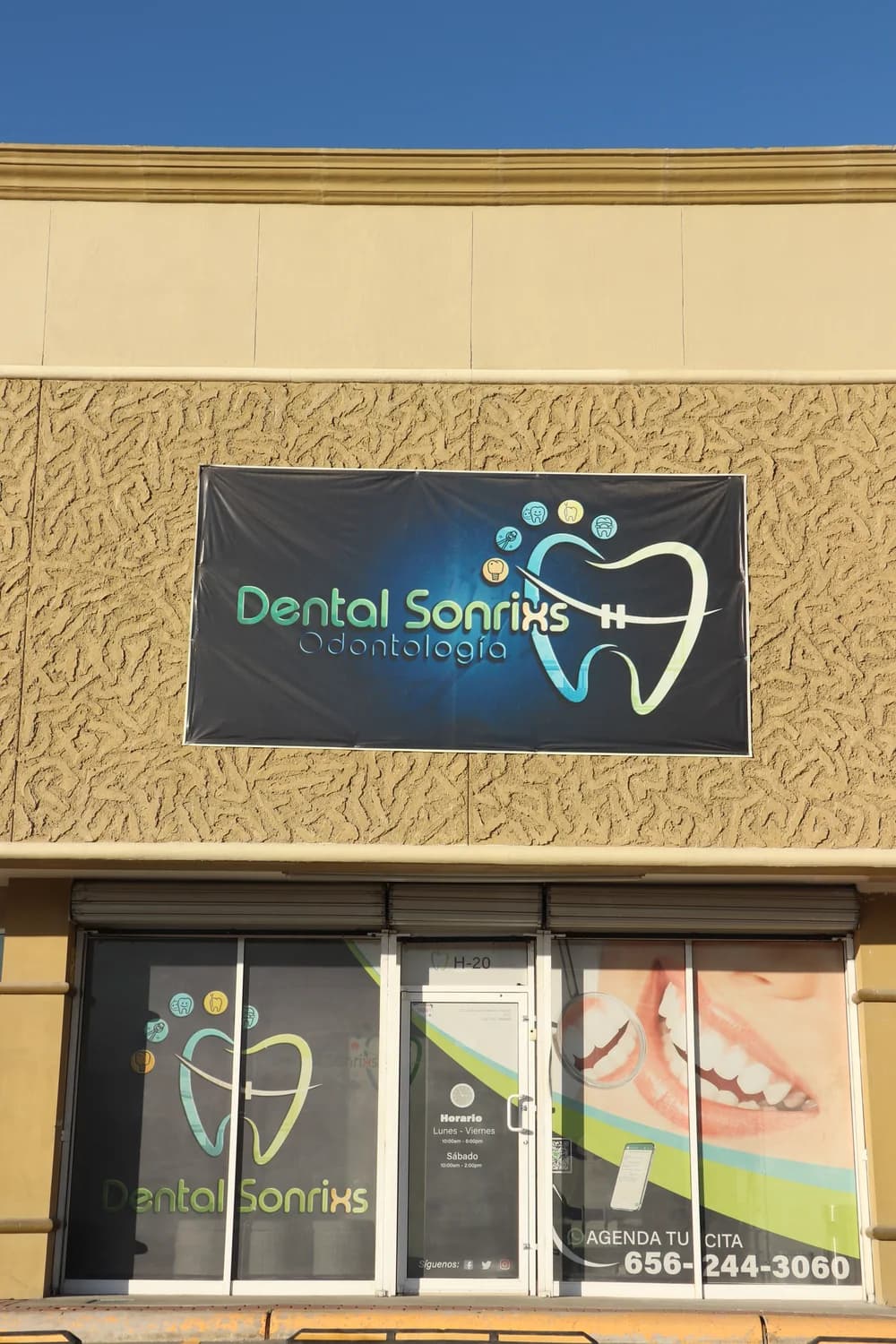 Fachada de Dental Sonrixs con el letrero sobre la entrada del local H20